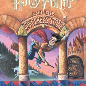 May include: A book cover featuring Harry Potter flying on a broomstick with a castle in the background. The title is "Harry Potter and the Sorcerer's Stone" with the author's name "J.K. Rowling" at the bottom.