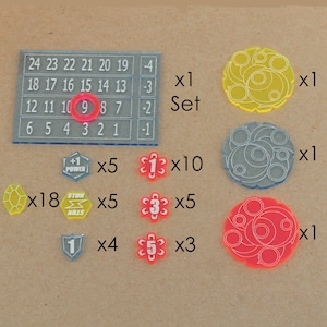 May include: A set of game pieces for a board game. The set includes a number tracker, 18 yellow gems, 5 red power tokens, 5 red stun tokens, 4 blue shields, 10 red 1 tokens, 5 red 3 tokens, and 3 red 5 tokens. The set also includes 3 large circular tokens in yellow, gray, and red.
