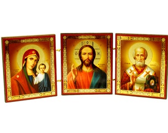 Könnte beinhalten: Ein dreiteiliges Holzsatz mit goldenen Verzierungen. Das linke Feld zeigt eine Darstellung der Jungfrau Maria, die das Jesuskind hält. Das mittlere Feld zeigt Jesus Christus mit erhobenen Händen zum Segen. Das rechte Feld zeigt den Heiligen Nikolaus mit einem goldenen Heiligenschein und einer Bischofsmitra.