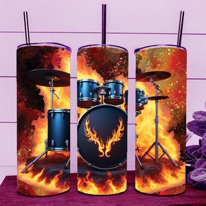 Puede incluir: Tres vasos de acero inoxidable con un diseño de batería envuelta en llamas. La batería es negra con un diseño de llamas rojas y amarillas. Los vasos son una excelente manera de disfrutar de tu bebida favorita.