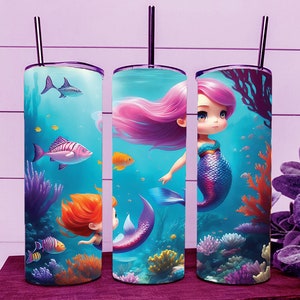 May include: Three stainless steel tumblers with a mermaid theme. Each tumbler features a different mermaid with pink, purple, and blue hair, swimming in a blue ocean with coral and fish. The tumblers have a purple lid and a straw.