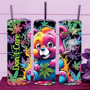 Peut inclure: Trois gobelets en acier inoxydable colorés avec un motif d'ours de dessin animé. L'ours tient une feuille de marijuana et il y a des feuilles de marijuana en arrière-plan. Le texte "Don't Care" est sur l'un des gobelets.