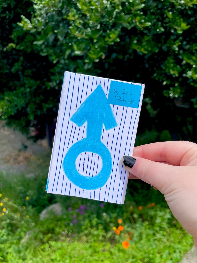 K&ouml;nnte beinhalten: Eine blau-wei&szlig; gestreifte Karte mit einem blauen Pfeil und einem Kreis darauf. Die Karte hat einen blauen Haftnotiz mit dem Text "by Zac Patrick" darauf.