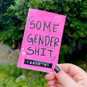 K&ouml;nnte beinhalten: Rosa Brosch&uuml;re mit dem Titel "SOME GENDER SHIT" und dem Text "ISSUE #1" auf dem Cover.
