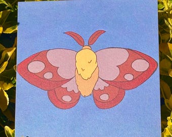 Puede incluir: Una impresión cuadrada que presenta una ilustración estilizada de una polilla centrada sobre un fondo azul claro. La polilla tiene un cuerpo difuso de color amarillo y melocotón, antenas rojo oscuro y alas con patrones en tonos rojo, rosa y morado.