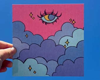 Puede incluir: Una impresión artística cuadrada que muestra un cielo rosa lleno de nubes superpuestas de color morado y azul claro. Un ojo con una pupila en forma de media luna y largas pestañas negras está centrado arriba, rodeado de pequeñas estrellas amarillas.