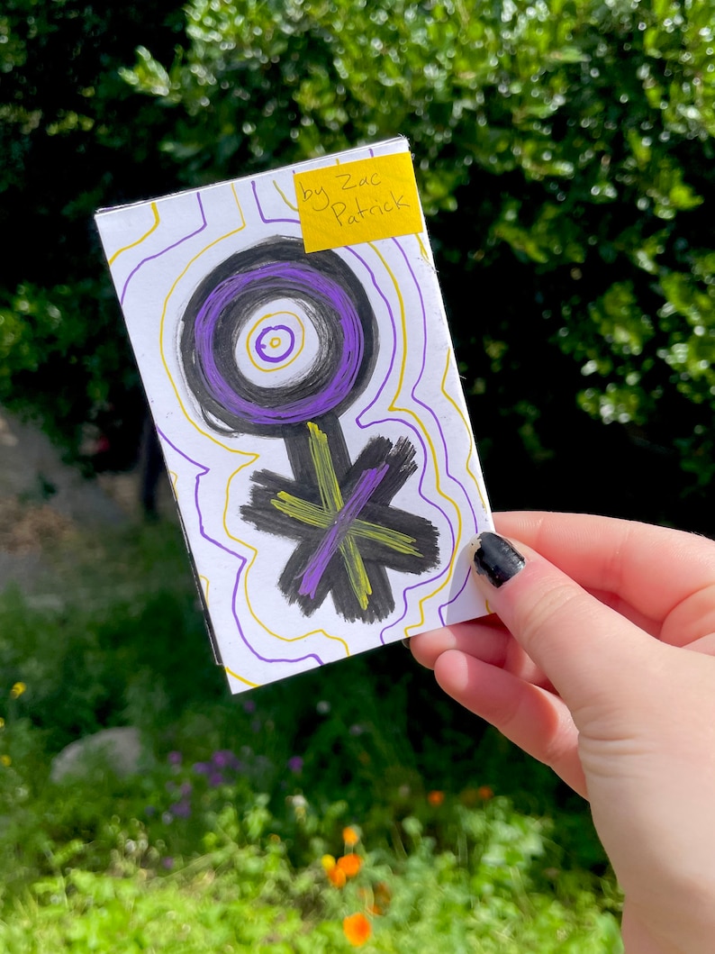 K&ouml;nnte beinhalten: Eine wei&szlig;e Karte mit einem schwarzen und violetten Symbol darauf. Das Symbol ist ein Kreis mit einem kleineren Kreis im Inneren und einer Linie, die sich nach unten erstreckt. Die Karte hat gelbe und violette Linien darauf gezeichnet. Ein gelber Haftnotiz mit dem Text "by Zac Patrick" befindet sich auf der oberen rechten Ecke der Karte.