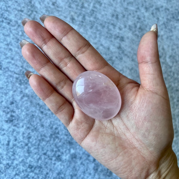 Natural polished gemstone rose quartz palm stone.