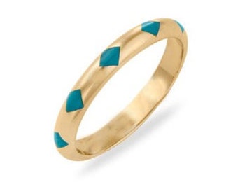 May include: A thin gold band ring with a row of turquoise blue diamonds around the band.
