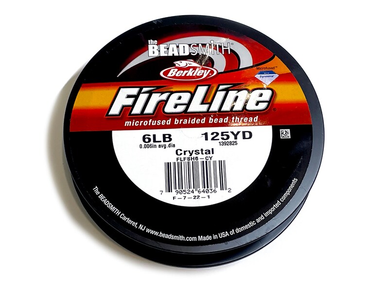 May include: A spool of black FireLine microfused braided bead thread, with a label that reads "6LB 0.006in avg. dia 125YD 1392825 Crystal FLFSH6-CY" and a barcode. The label also includes the text "The BEADSMITH Carteret, NJ www.beadsmith.com Made in USA of domestic and imported components."