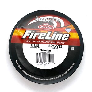 May include: A spool of black FireLine microfused braided bead thread in Smoke color. The spool is labeled with 6LB, 125YD, 0.006in avg.dia, and FLFSH6-42. The spool is made in the USA of domestic and imported components.