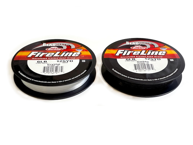 May include: Two spools of Berkley FireLine microfused braided bead thread. The spool on the left is Crystal color and the spool on the right is Smoke color. Both spools are 6lb test and 125 yards.