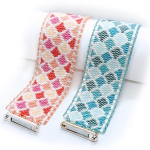 May include: Two beaded bracelets with geometric patterns. One bracelet is pink, orange, and white. The other bracelet is blue, green, and white.