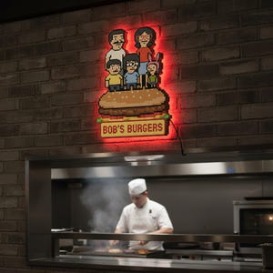 May include: A pixelated sign for Bob's Burgers, featuring the family atop a burger, illuminated with red neon against a brick wall. The sign reads "BOB'S BURGERS" in yellow letters. A chef is seen cooking in the background.