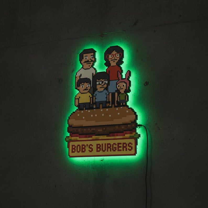 May include: Pixelated wall art featuring the Bob's Burgers family standing on a large burger. The sign below the burger reads "BOB'S BURGERS". The art has a green neon glow around the characters and burger.