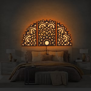 May include: A black wooden headboard with a decorative mandala design. The headboard is lit from behind with warm white lights, creating a cozy and inviting atmosphere.