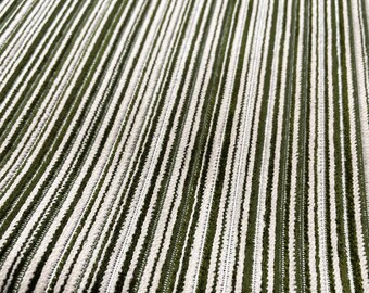 May include: Close-up of a green and white striped fabric with a soft, textured surface.