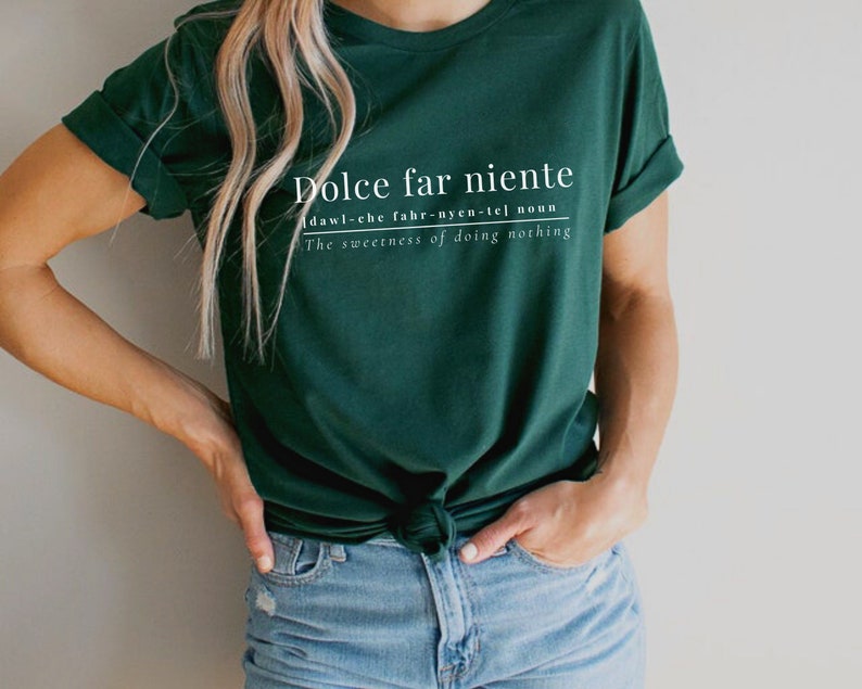 May include: A dark green t-shirt with white text that reads "Dolce far niente" and defines the phrase as "dawl-che fahr-nyen-tel noun The sweetness of doing nothing".
