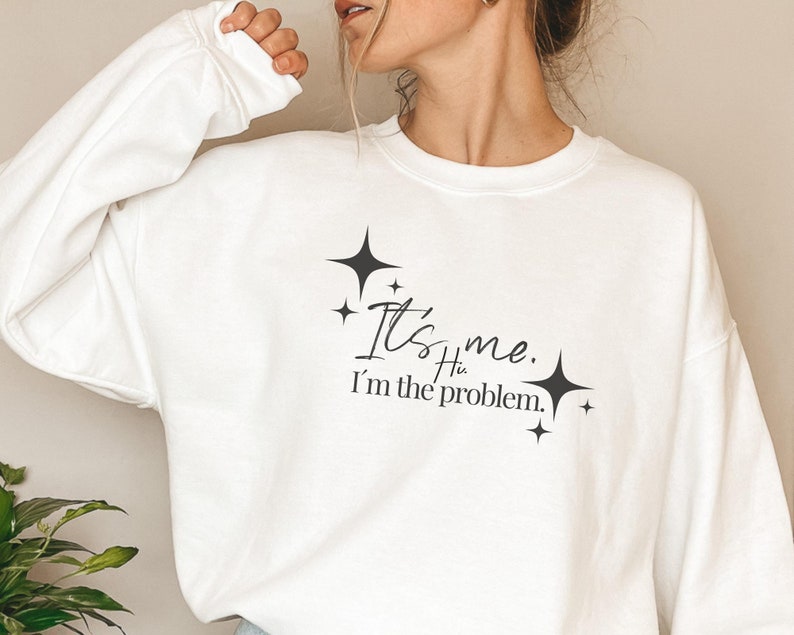 May include: White sweatshirt with a black graphic that says "It's me. I'm the problem." with stars around the text.
