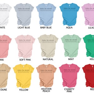 May include: A collage of 15 t-shirts in various colors, each featuring the text "Dolce far niente" in black. The text is centered on the front of each shirt. The shirts are arranged in three rows of five, with the colors of the shirts changing from row to row. The colors of the shirts are white, light blue, baby blue, aqua, lilac, pink, soft pink, natural, mint, kelly, sand dune, yellow, heather peach, charity pink, and red.