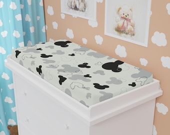 Op de afbeelding: Een witte commodehoes met een grijs en zwart Mickey Mouse-print. De hoes is op een witte commode met drie lades.