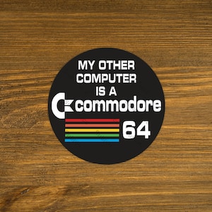 May include: A black and white sticker with the text "My other computer is a Commodore 64" and a rainbow stripe design.