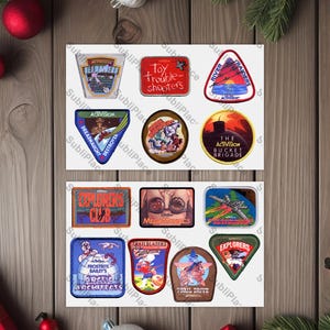 May include: A sheet of paper with 12 colorful patches, each with a different design and text. The patches are for a video game called Activision.