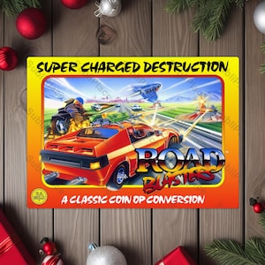 May include: A retro-style Road Blasters arcade game print with a vibrant orange and yellow border. The artwork features a red sports car, a motorcycle, and a futuristic jet. Text includes "SUPER CHARGED DESTRUCTION" and "ROAD BLASTERS".
