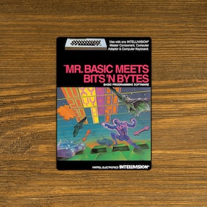 May include: A vintage game cartridge for the Intellivision console. The cartridge is black with a colorful image of a futuristic scene with a spaceship and a character in a spacesuit. The text on the cartridge reads "Mr. Basic Meets Bits'n Bytes" and "Basic Programming Software".