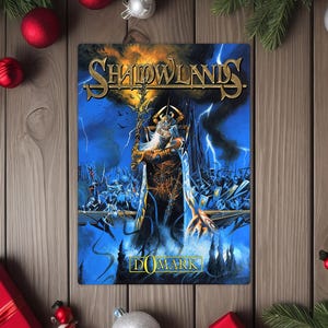 May include: A rectangular metal sign featuring the title "Shadowlands" in gold lettering. The artwork depicts a wizard with a long white beard, staff, and armor, set against a blue and yellow background with lightning and a battle scene. The sign is surrounded by Christmas decorations.