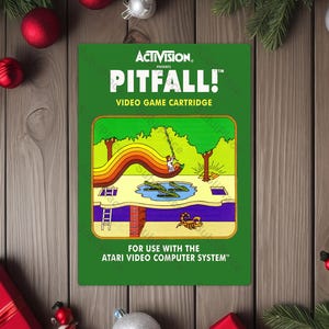 May include: A green Pitfall! video game cartridge with a colorful illustration of a swinging figure, crocodiles, and a rainbow-colored path. The cartridge is for the Atari Video Computer System.