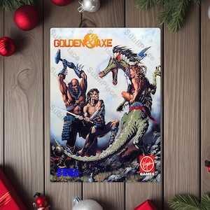 May include: A rectangular Golden Axe video game cover featuring three muscular characters battling a dragon. The cover art has a fantasy theme with the game's title at the top. The Virgin Games logo is at the bottom.
