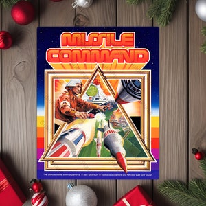 May include: A vintage "Missile Command" arcade game poster. The artwork features a pilot in a flight suit, rockets, and a futuristic cityscape. The title is in bold orange letters against a starry blue background. The poster has a retro aesthetic.