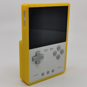 May include: A yellow handheld gaming console with a white faceplate. The console has a directional pad, four buttons, and a screen. The console is in a yellow case.