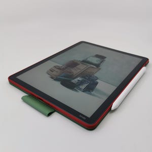 May include: A Kindle e-reader with a red and green case, displaying an image of a bottle. A white stylus rests on the side. The word "Kindle" is visible on the device.