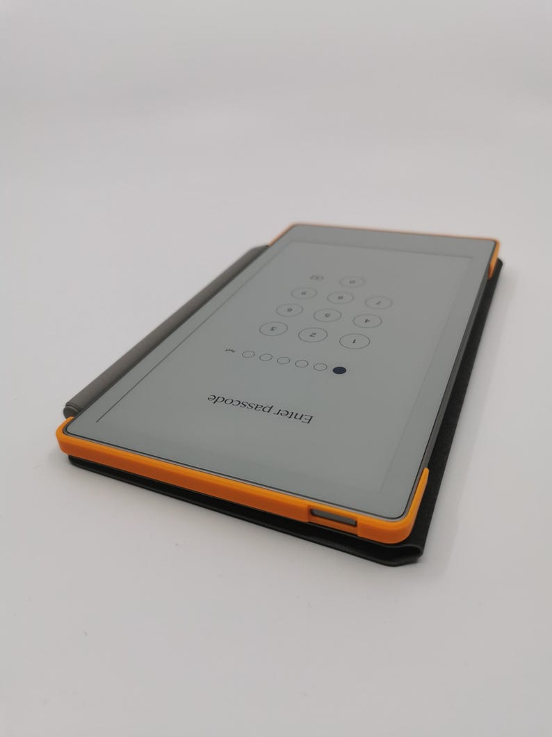 May include: A rectangular tablet with a gray screen displaying a passcode entry screen. The tablet has an orange border and is in a black case. A gray stylus rests on the tablet. The text "Enter passcode" is visible.