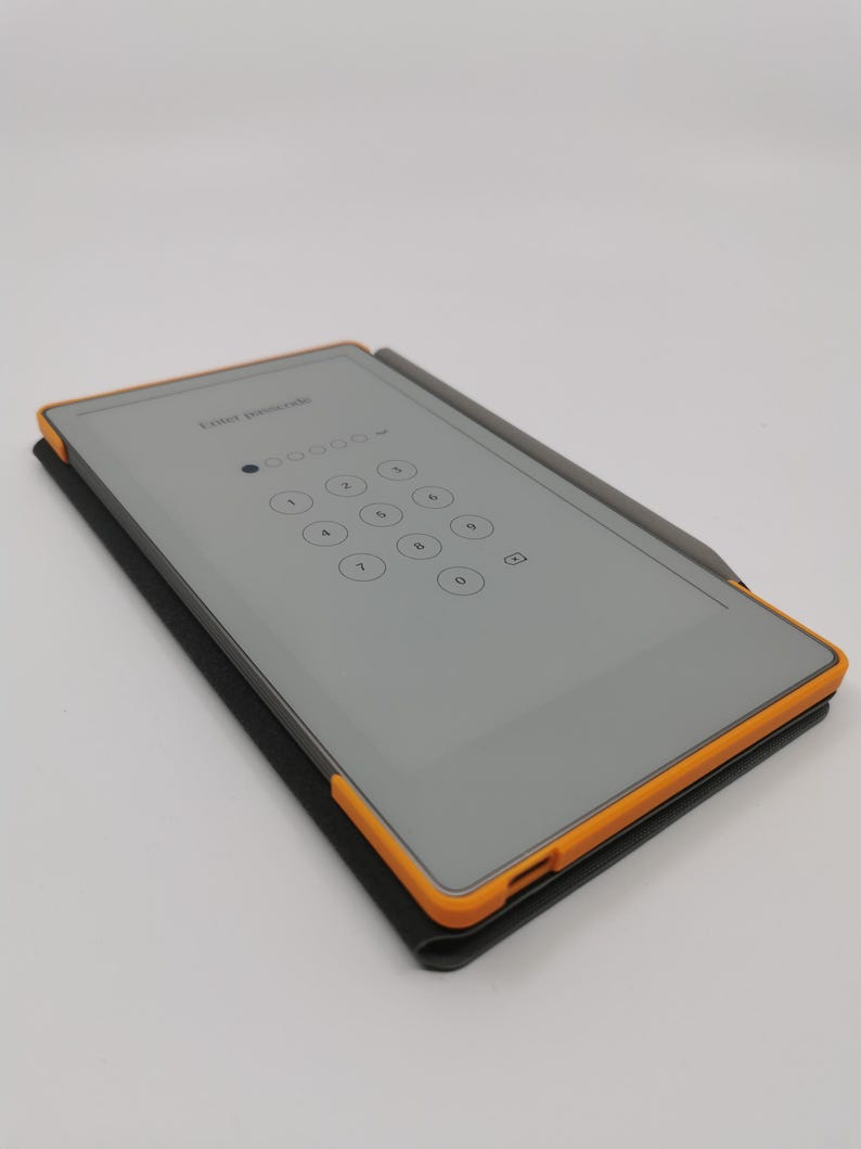 May include: A gray tablet with an orange frame and a stylus, resting on a black case. The screen displays a numeric keypad with the text "Enter passcode" at the top. The stylus is gray.