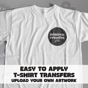 May include: A white short-sleeved t-shirt featuring a black circular graphic on the left chest with the white text mint&co. creative studio. A white banner across the bottom displays the black text EASY TO APPLY T-SHIRT TRANSFERS UPLOAD YOUR OWN ARTWORK.