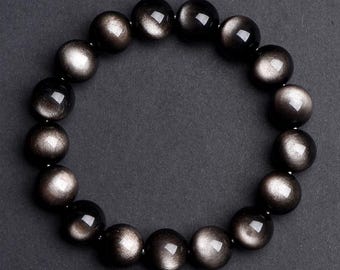 May include: A black gemstone bracelet with a silver sheen. The bracelet is made of round beads and is strung on a stretchy cord.