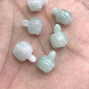 May include: Six small, green jade turtle figurines. The turtles are carved in a realistic style and have detailed shells.