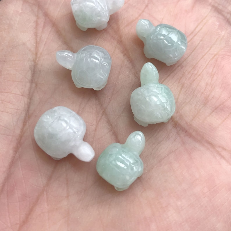 May include: Six small, green jade turtle figurines. The turtles are carved in a realistic style and have detailed shells.