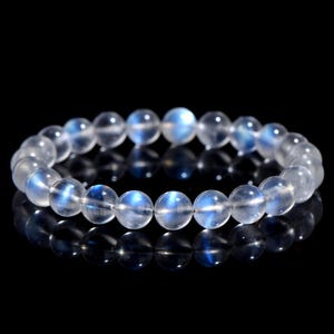 Op de afbeelding: Een witte stenen armband met iriserende blauwe maansteen kralen.