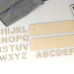 Puede incluir: Letras del alfabeto de madera en may&uacute;sculas, dispuestas en orden alfab&eacute;tico, con las letras A a F en la parte inferior y G a Z en la parte superior. Tambi&eacute;n se incluyen dos piezas rectangulares de madera.