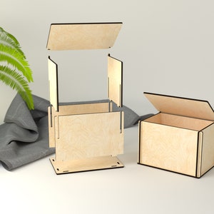 Op de afbeelding: Twee houten dozen met deksels. De doos links is geassembleerd en heeft een basis, zijkanten en een bovenkant. De doos rechts is open en laat de binnenkant zien. Beide dozen zijn gemaakt van licht hout met een natuurlijke afwerking.