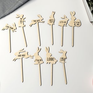 May include: Ten wooden bunny rabbit garden stakes with different phrases on them, including "Look Down", "This Way!" and "Start Here".