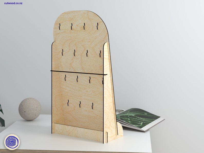May include: A wooden earring display stand with a rounded top and a slanted base. The stand has multiple holes for hanging earrings.