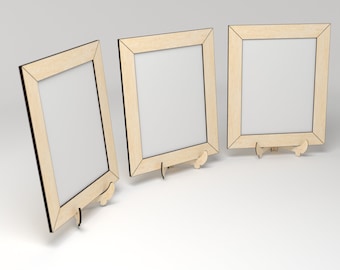 May include: Three wooden picture frames with a light wood finish and black trim. The frames are standing on a white surface.