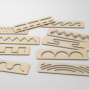 May include: Set of ten wooden tracing stencils with various patterns, including waves, zigzags, and lines. The stencils are light brown and have black lines.