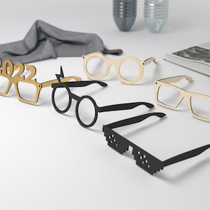 May include: Five pairs of novelty glasses, including a pair with the year 2022, a pair with a lightning bolt, a pair of round glasses, a pair of rectangular glasses, and a pair of black sunglasses with a pixelated design.