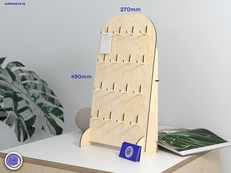 May include: A wooden display stand with hooks for hanging earrings or other small items. The stand is 69 cm tall and 49 cm wide. It has a light wood finish and is made of plywood.